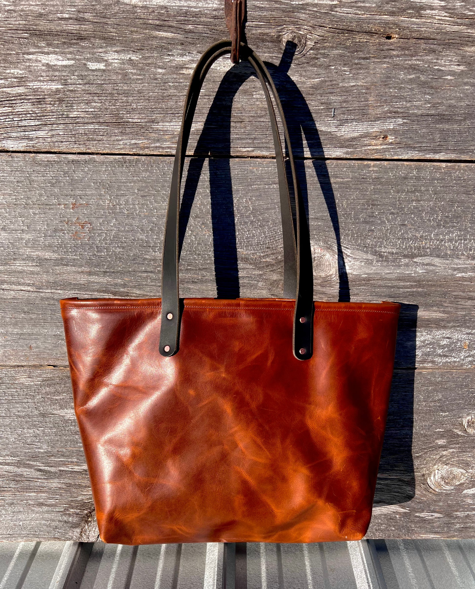 Chestnut brown leather Wanderer tote bag with black leather straps and copper hardware.

Simple. Rugged. Dependable. 
