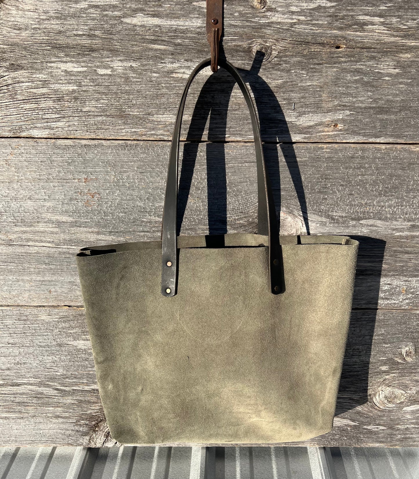 Large green suede leather Wanderer tote bag with black leather straps and copper hardware. 

Simple. Rugged. Dependable. 