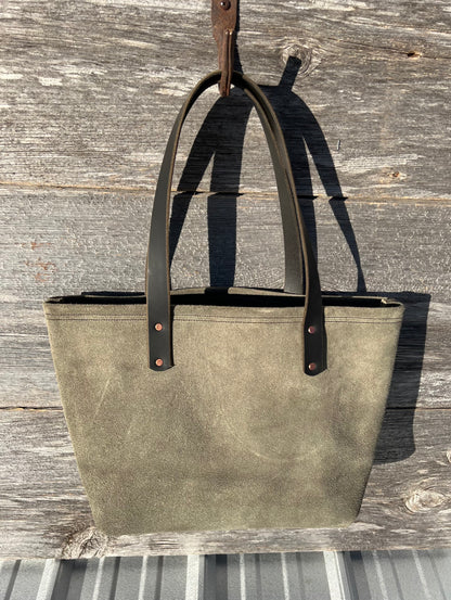 Medium green suede Wanderer tote bag with black leather straps and copper hardware. 

Simple. Rugged. Dependable. 